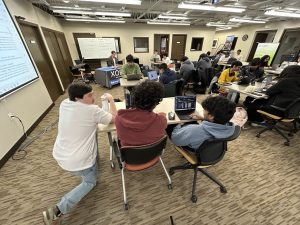 Tyler Faulkner with Xorbix coaches students during a day-long hackathon.